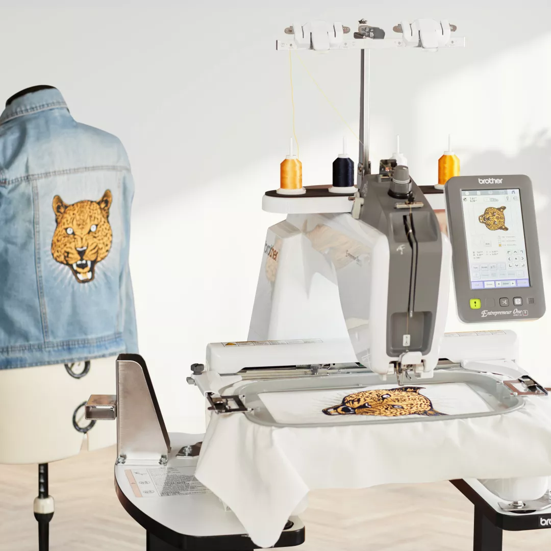 Image of the Brother PR1X embroidering a built-in design of a cheetah on fabric and a completed jacket back with the same design